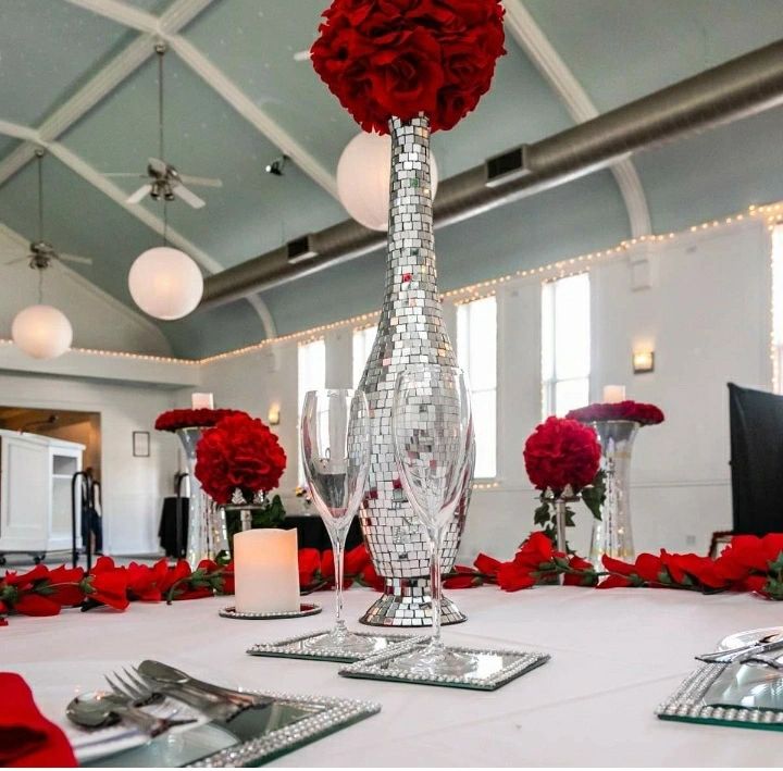 Elegant wedding venue with red roses and mirrored centerpiece
